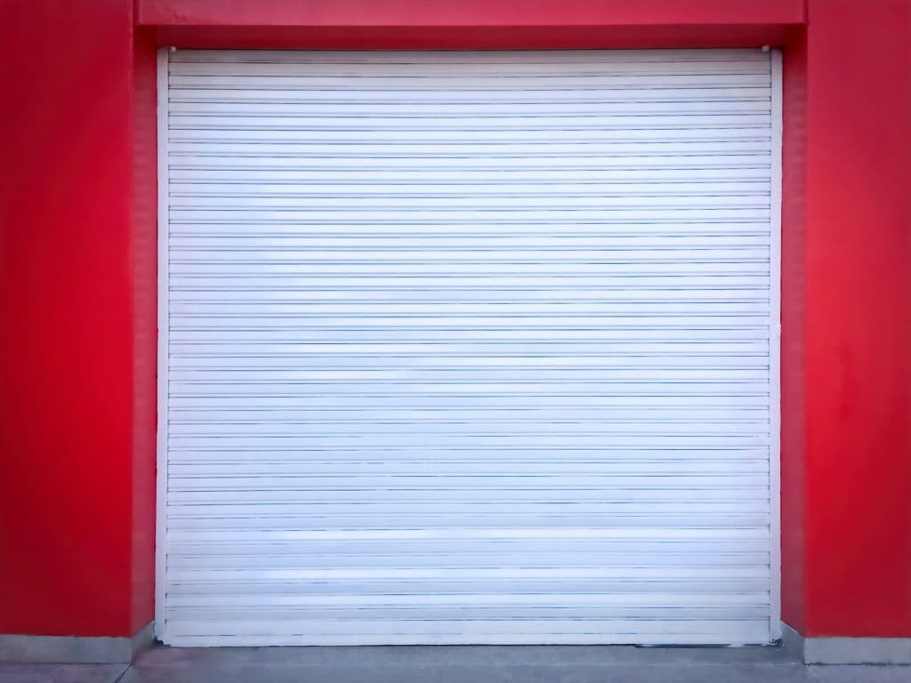 White Roll-up Door on Red Wall of the Garage